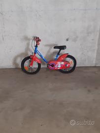 Bici rossa e blu b-twin con rotelle