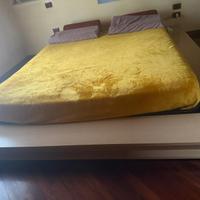 Letto matrimoniale basso in legno chiaro con rete