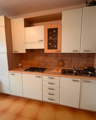 Cucina con frigo e fornelli con fuochi a gas