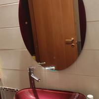 Bagno con lavabo, specchiera e mobiletto