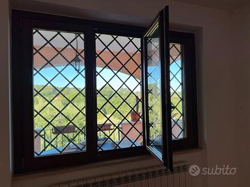 Finestra in legno con inferriata e zanzariera