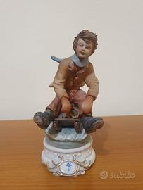 Statua porcellana Capodimonte bimbo su slitta