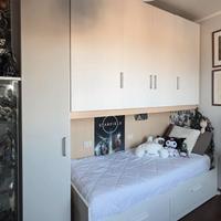 Set cameretta con armadi a ponte e divano letto.