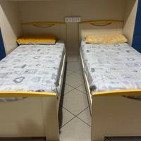 Cameretta con 2 letti singoli in legno chiaro