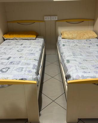 Cameretta con 2 letti singoli in legno chiaro