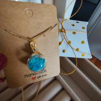 collana con ciondolo a sfera contenente stelline 