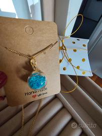 collana con ciondolo a sfera contenente stelline 