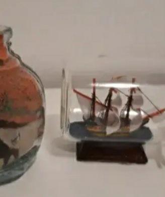 bottiglie in vetro con nave e sabbia colorata 