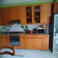 Cucina in legno e vetrinetta con lavandino e cappa