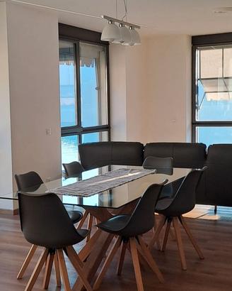 Tavolo con piano in vetro e base in legno