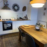 Cucina con elettrodomestici, tavolo e credenza