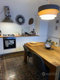 Cucina con elettrodomestici, tavolo e credenza