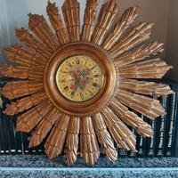 Orologio da parete con cornice in legno dorato.