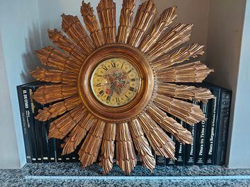 Orologio da parete con cornice in legno dorato.