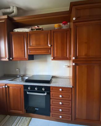 Cucina in legno completa di tavolo e mobile