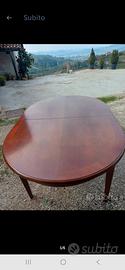 tavolo in legno ovale con decoro sulle gambe