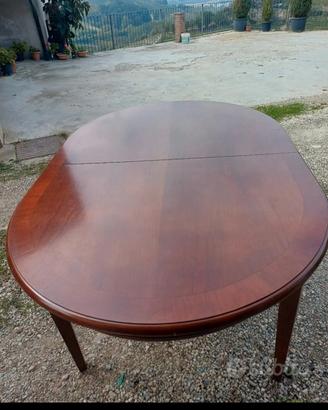 tavolo in legno ovale con decoro sulle gambe