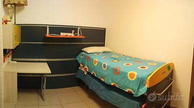 cameretta con letti scorrevoli, scrivania e aradio