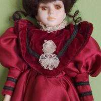 Bambola di porcellana con vestito color porpora