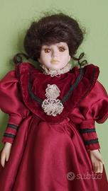 Bambola di porcellana con vestito color porpora