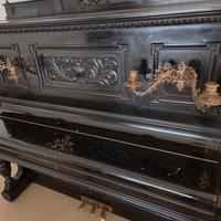 Antico pianoforte a muro nero