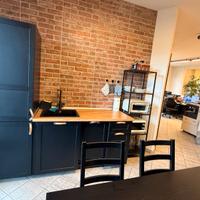 Cucina Ikea nera munita di frigo e lavastoviglie