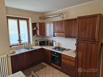 Cucina in legno color noce dotata di alcuni elettr