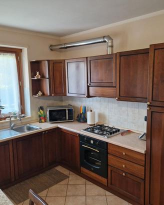 Cucina in legno color noce dotata di alcuni elettr