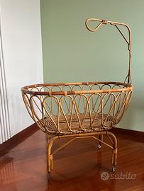 Culla vintage in rattan su rotelle