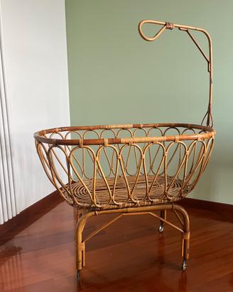 Culla vintage in rattan su rotelle