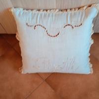 Cuscino con cifre ricamato a mano.