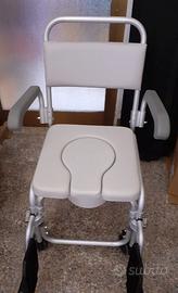 Sedia a rotelle, provvista di secchio estraibile.