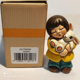 Thun bambino con coniglio in braccio
