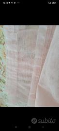 Due tende in voile rosa chiaro.