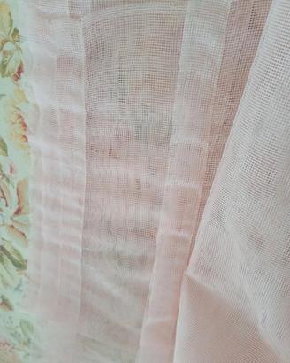 Due tende in voile rosa chiaro.