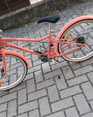 Bicicletta color pesca con disegni da città