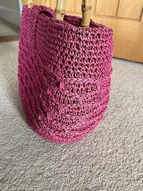 Piccola borsa lavorata a maglia rosa con manici in