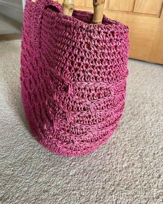 Piccola borsa lavorata a maglia rosa con manici in