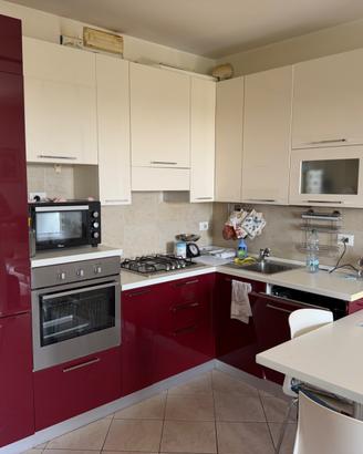 Cucina con elettrodomestici e camera da letto