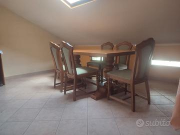 tavolo con sedie e poltrona e angoliera