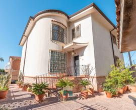 Elegante villa trifamiliare con giardino