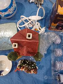 casetta illuminata natalizia con persoaggi