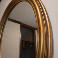 Specchio ovale con cornice in legno dorato