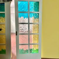 Porta scorrevole in legno con parti in vetro