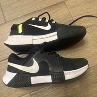 Scarpe da tennis per terra rosa