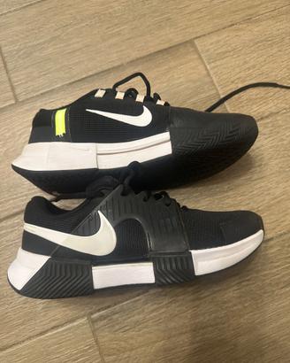 Scarpe da tennis per terra rosa