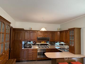 Cucina in legno con piano cottura e tavolo